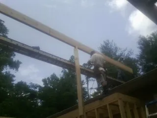 Carpenter setting a ridge beam over a new addition frame — Ice Dam Removal by Roofing Brothers in Beachwood