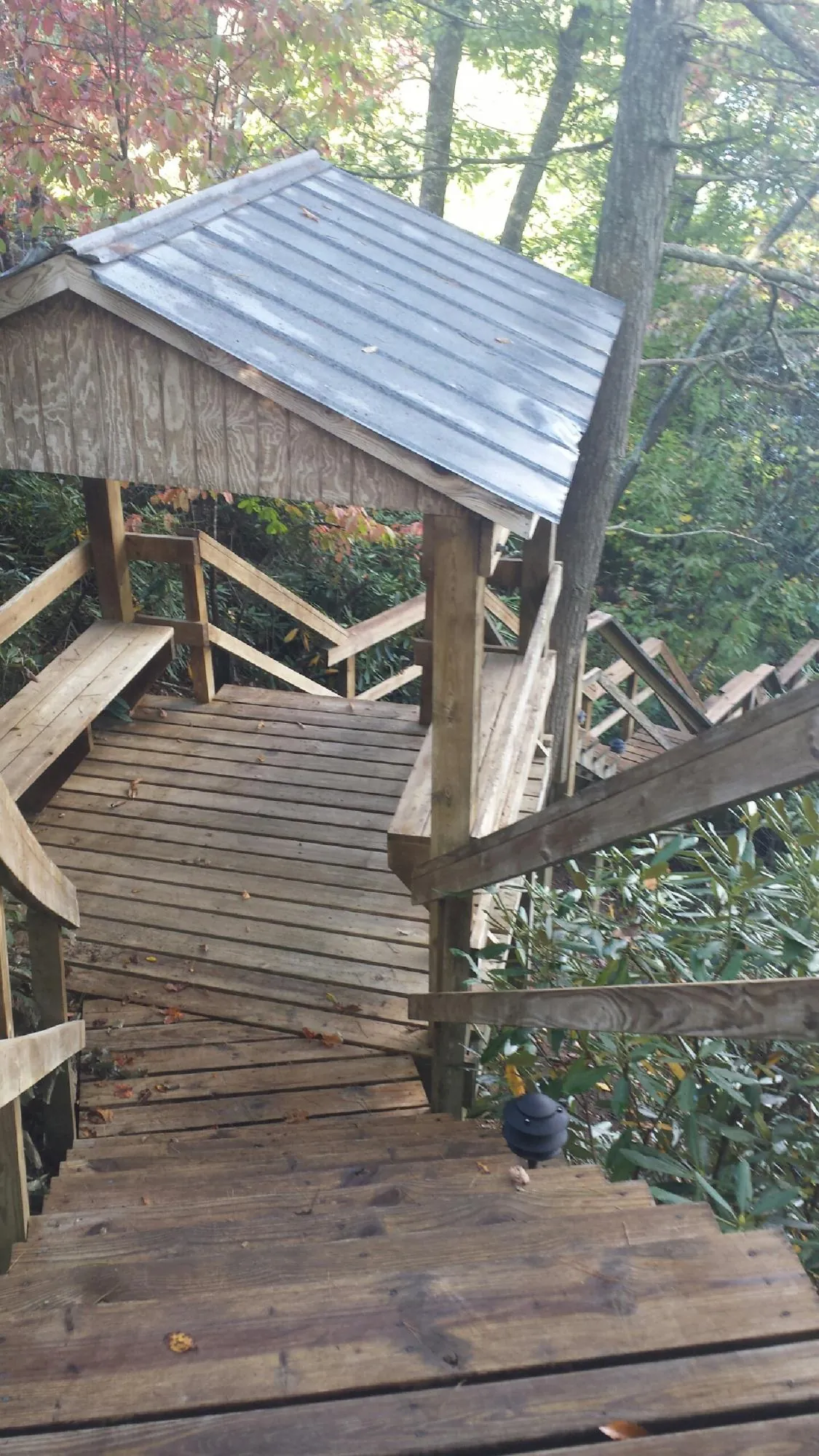 Metal roofed shelter over wooden steps on a wooded walkway — Skylight Repair & Installation work by our crew in Beachwood
