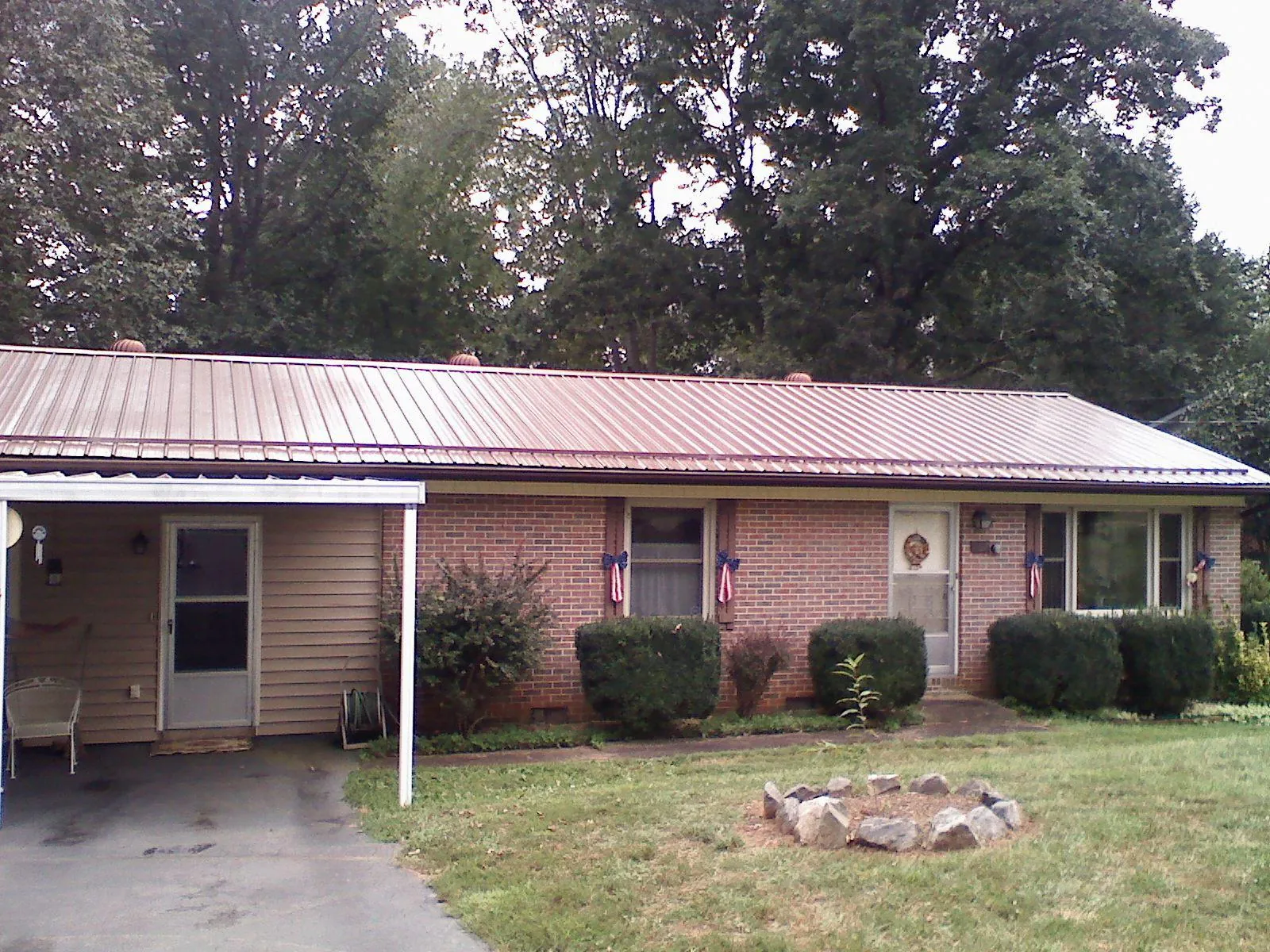 Bronze metal roof and carport on a brick ranch home — Roof Repair work by our crew in Beachwood
